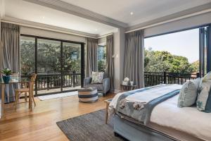 a bedroom with a large bed and a balcony at 11 Bonabali in Ballito
