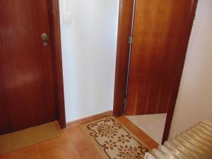 a hallway with two doors and a rug on the floor at Casa de Campo em Taipa in Coruche