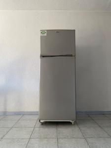 a white refrigerator in a room with a wall at Cozy house in the Angelópolis area in La Concepción