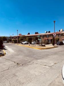 an empty street with cars parked in a parking lot at Cozy house in the Angelópolis area in La Concepción
