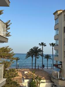 a view of a beach with palm trees and the ocean at Apartamento Blanco Albir in Albir
