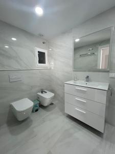 a white bathroom with a toilet and a sink at Apartamento Blanco Albir in Albir +12 photos