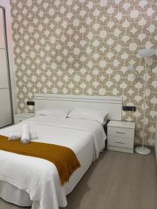 a bedroom with a white bed and a patterned wall at Rota Beach Loft in Rota