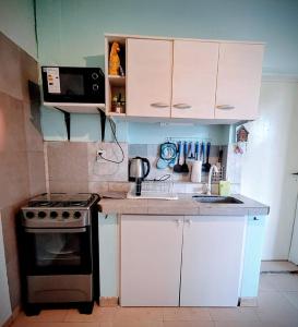 a small kitchen with a stove and white cabinets at Lo de Julia in Formosa