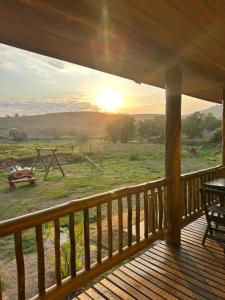 a view from the deck of a cabin with the sun setting at Recanto do curio in Aparecida