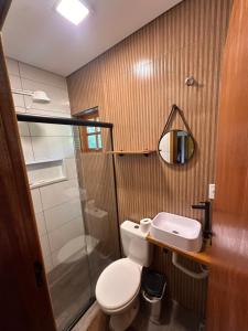 a bathroom with a toilet and a sink and a mirror at Recanto do curio in Aparecida +49 photos