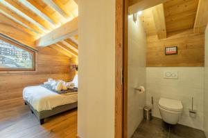 a bedroom with a bed and a toilet in a room at Chalet Téléporté Jacuzzi Hammam Cheminée 14 pers - MultiPass in Les Gets +42 photos