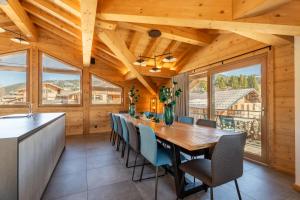 a dining room with a large wooden table and chairs at Chalet Téléporté Jacuzzi Hammam Cheminée 14 pers - MultiPass in Les Gets