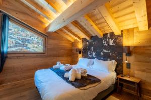 a bedroom with a bed with stuffed animals on it at Chalet Téléporté Jacuzzi Hammam Cheminée 14 pers - MultiPass in Les Gets