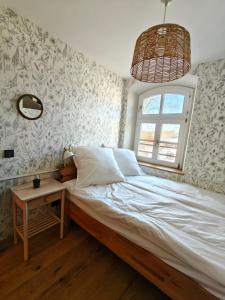 a bedroom with a bed with a window and a table at 3sine - Ihr besonderer Gasthof im Bahnhof Deisenhofen in Oberhaching