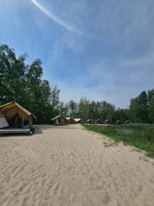 a sandy beach with some tents and some trees at Kaniv Fish Club in Kaniv