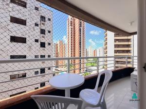 a balcony with a white table and two chairs at Brisa do Mar Residence by Holiday Stays in Fortaleza