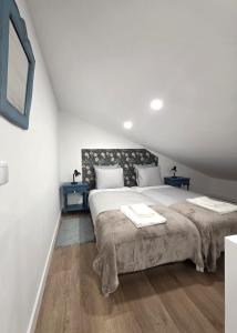 a bedroom with a large bed with two tables at Casinhas da Ajuda nº15 in Lisbon