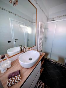 a bathroom with a sink and a large mirror at In Via Capri 1991 APARTMENT in Follonica +43 photos