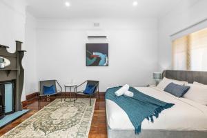 a bedroom with a bed and a fireplace at North Perth 3BR Home Steps To Hyde Park & Dining in Perth
