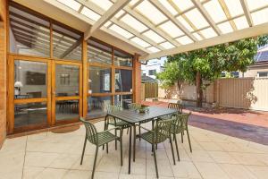 a dining table and chairs on a patio with awning at North Perth 3BR Home Steps To Hyde Park & Dining in Perth