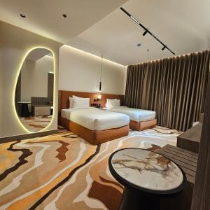a hotel room with two beds and a table at Wahed Numas in Hail