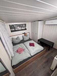 a bedroom with a bed with two pink pillows on it at Waldidyll in Plötzky