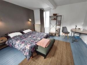 a bedroom with a bed and a chair and a table at La petite Tourelle Ruelle de la Fontaine in Péronne