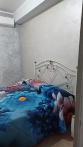 a bedroom with a bed with a blue comforter at Perla del mare Ionio in Fondachello