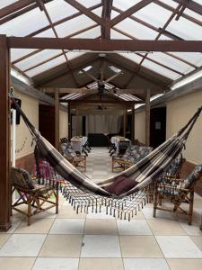 a hammock in the middle of a room with chairs at Pousada Laviê Morada de Leste in Pontal do Paraná