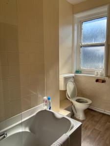 a bathroom with a bath tub and a toilet at Dover Priory Hotel in Dover