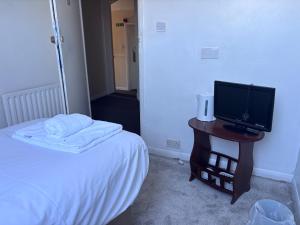 a bedroom with a bed and a television on a table at Dover Priory Hotel in Dover