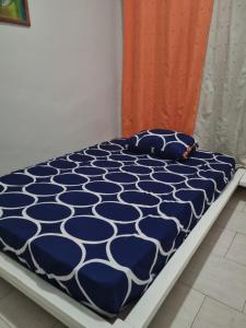 a bed with a blue and white comforter on it at Borges Place in Praia