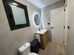 a bathroom with a toilet and a sink and a mirror at Rubín 21 in Redondela +23 photos