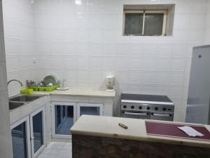 a white kitchen with a sink and a stove at Borges Place in Praia +4 photos