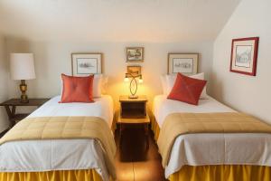 two beds in a hotel room with red pillows at Smugglers Trove in Cambridge