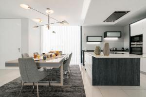 a kitchen and dining room with a table and chairs at Luxury Ocean View Villa I Swimming pool I Vincents Place in Estreito da Calheta +46 photos