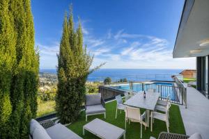 a patio with a table and chairs and a view of the ocean at Luxury Ocean View Villa I Swimming pool I Vincents Place in Estreito da Calheta