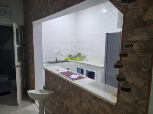a white kitchen with a sink and a counter at Borges Place in Praia