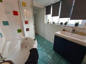a bathroom with a tub and a sink at La petite Tourelle Ruelle de la Fontaine in Péronne +18 photos