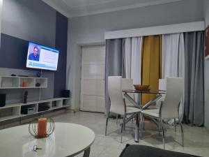 a living room with a table and chairs and a tv at Borges Place in Praia