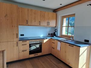 a kitchen with wooden cabinets and a stove top oven at Ferienwohnung Altrach in Aurach bei Kitzbuhel