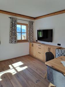 a living room with a television and a wooden table at Ferienwohnung Altrach in Aurach bei Kitzbuhel