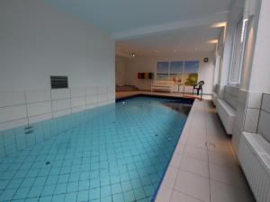 a large swimming pool with a blue tile floor at Ferienwohnung in Westerland auf Sylt in Westerland +6 photos