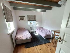 a bedroom with two beds and a desk and a table at 4 star holiday home in SÖLVESBORG in Sölvesborg