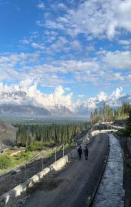 two people are walking down a dirt road at Skarchan Resort Skardu in Skardu