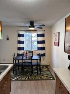 a kitchen with a table with chairs and a ceiling fan at Stunning 1 Bedroom Apartment in Camrose