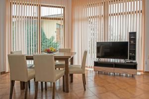 a dining room with a table with chairs and a television at Montemar Villas in Sunny Beach
