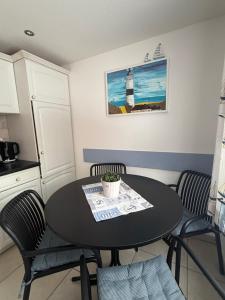 a kitchen with a black table and chairs and a table at Haus Ostseewind in Zingst