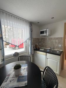 a kitchen with a table and chairs and a kitchen with a sink at Haus Ostseewind in Zingst