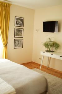a bedroom with a bed and a tv on a wall at Guest house ''8 smilgos'' in Klaipėda