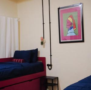 a bedroom with a bed and a painting on the wall at Sela Stay Prawirotaman in Yogyakarta
