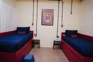 two beds in a room with blue and red at Sela Stay Prawirotaman in Yogyakarta
