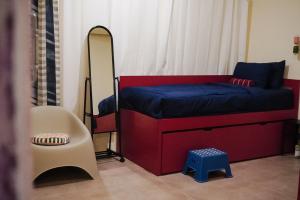 a small bedroom with a red bed and a mirror at Sela Stay Prawirotaman in Yogyakarta +52 photos