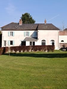 a large white house with a large grass field at domaine des trois rivières in Sainte-Marguerite-de-Viette
